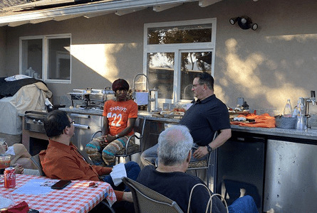 People gathered around an outdoor kitchen